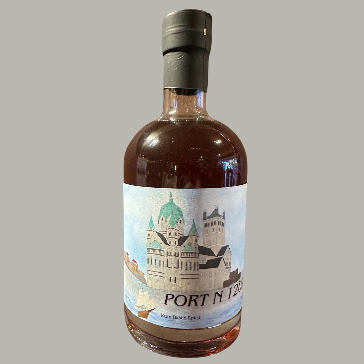 Port N 1209, 70cl, Rum-basierte Spirituose in einer runden Flasche mit schwarzer Wachskapsel. Bernsteinfarbene Flüssigkeit, handgezeichnetes Etikett mit historischem Gebäude, Segelschiff und Wasserlandschaft.