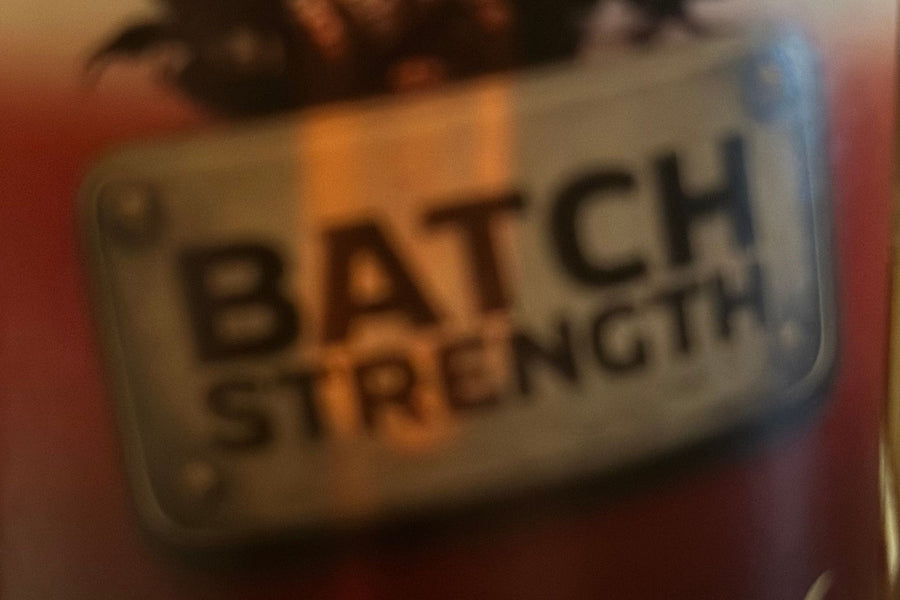 Nahaufnahme eines Whisky-Etiketts mit der Aufschrift „Batch Strength“, leicht unscharf und in warmen Farben gehalten.